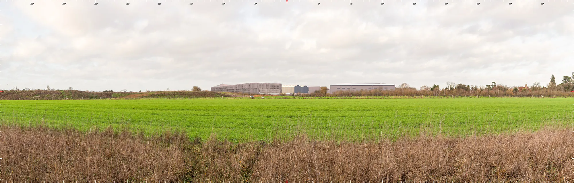 A computer generated image of a proposed studio redevelopment viewed across intervening fields and mineral extraction works.